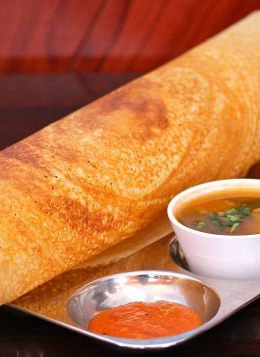 Traditional South Indian plain dosa with crispy texture, served with chutney and sambar.